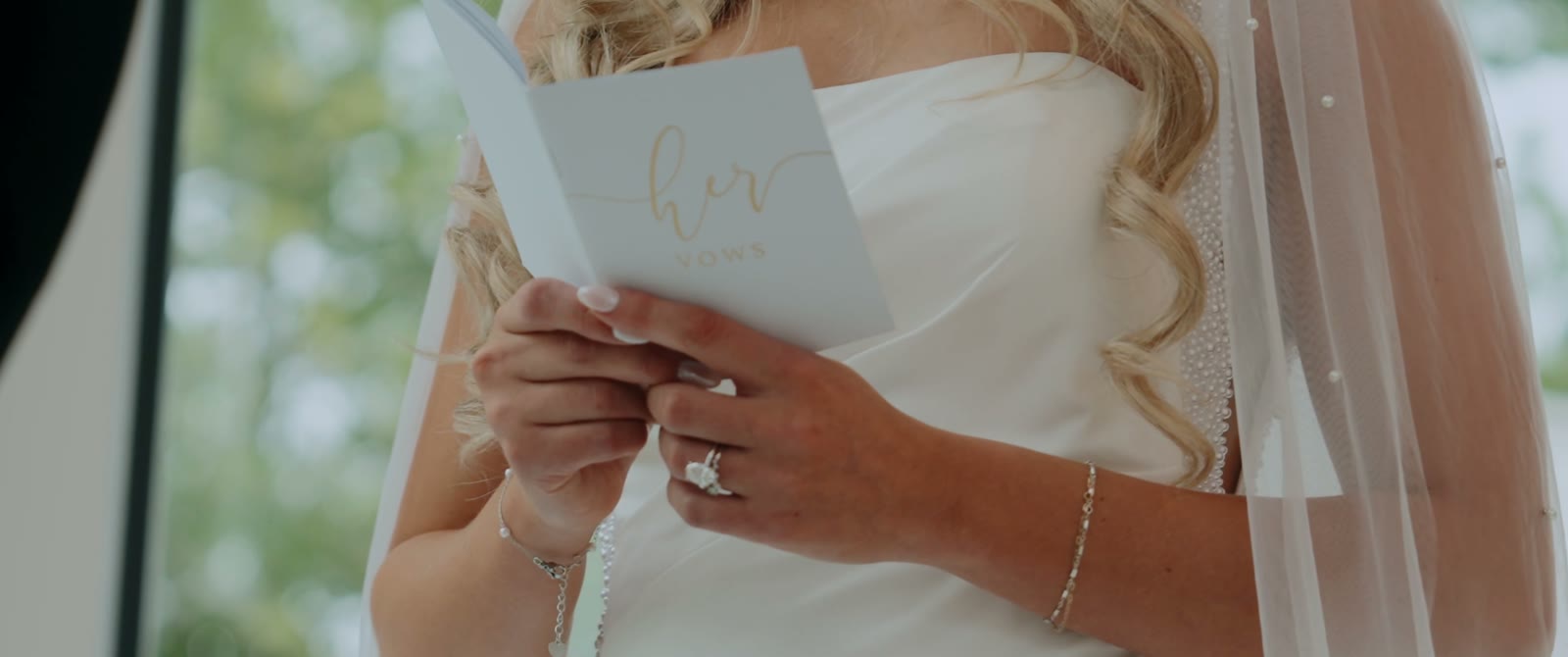 Close view of the bride's hands holding her vow book as she reads her vows.