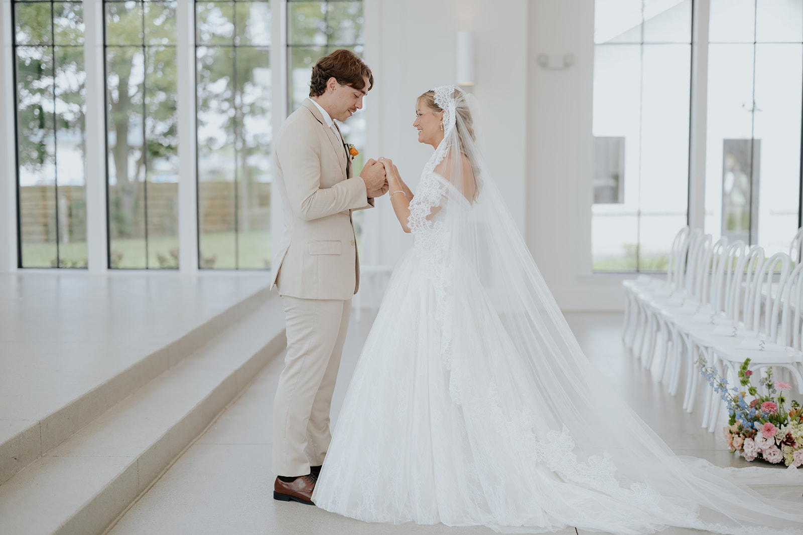 Cami and Trey hold hands during their first look in the bright white chapel at Westwood Vowery & Estate.