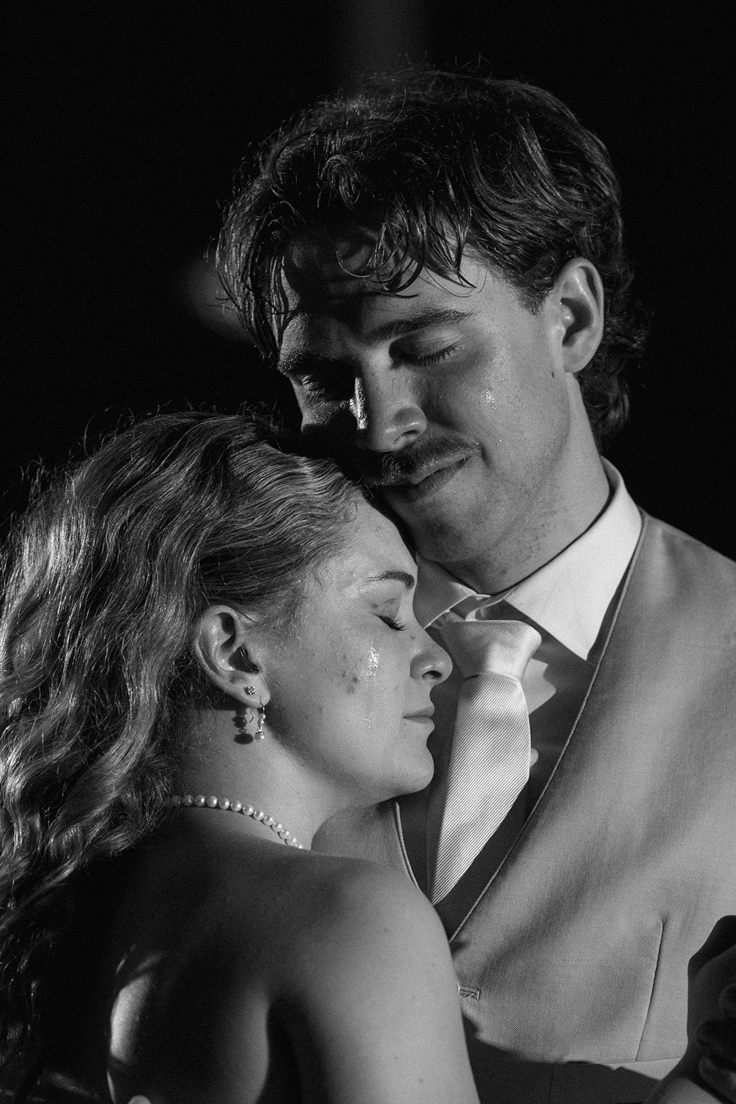 Black and white close-up of Cami and Trey slow dancing with their eyes closed.