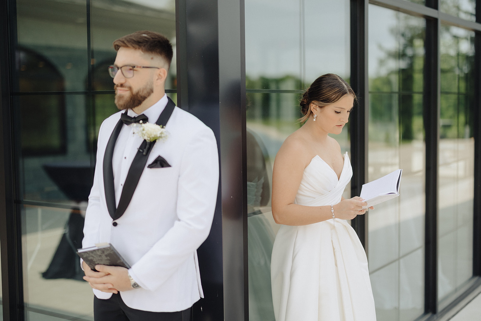Dallas and Beau stand back to back on either side of a wall, each reading a vow book