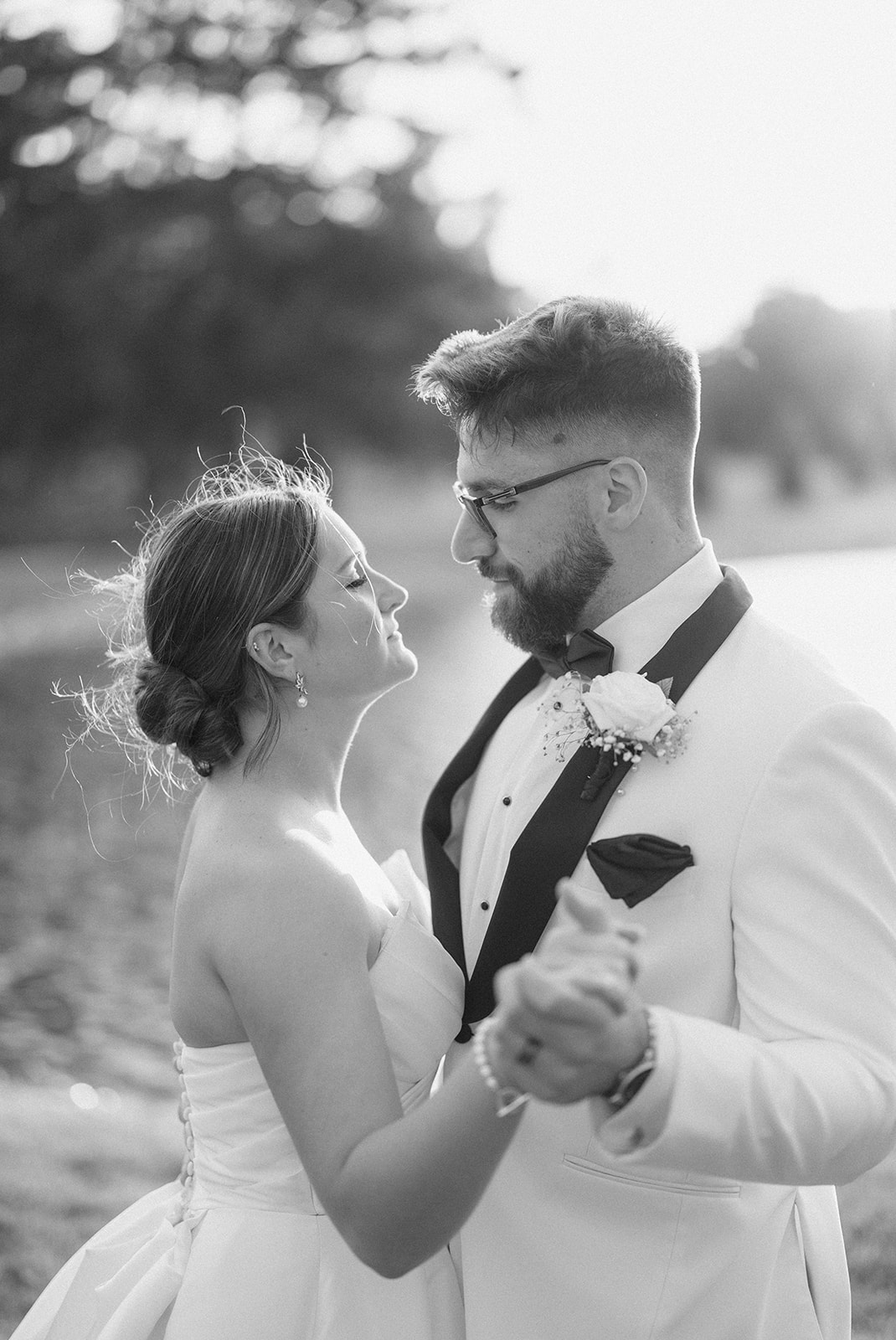 Black and white of Dallas and Beau slow dancing by the water, her eyes closed as he looks down.