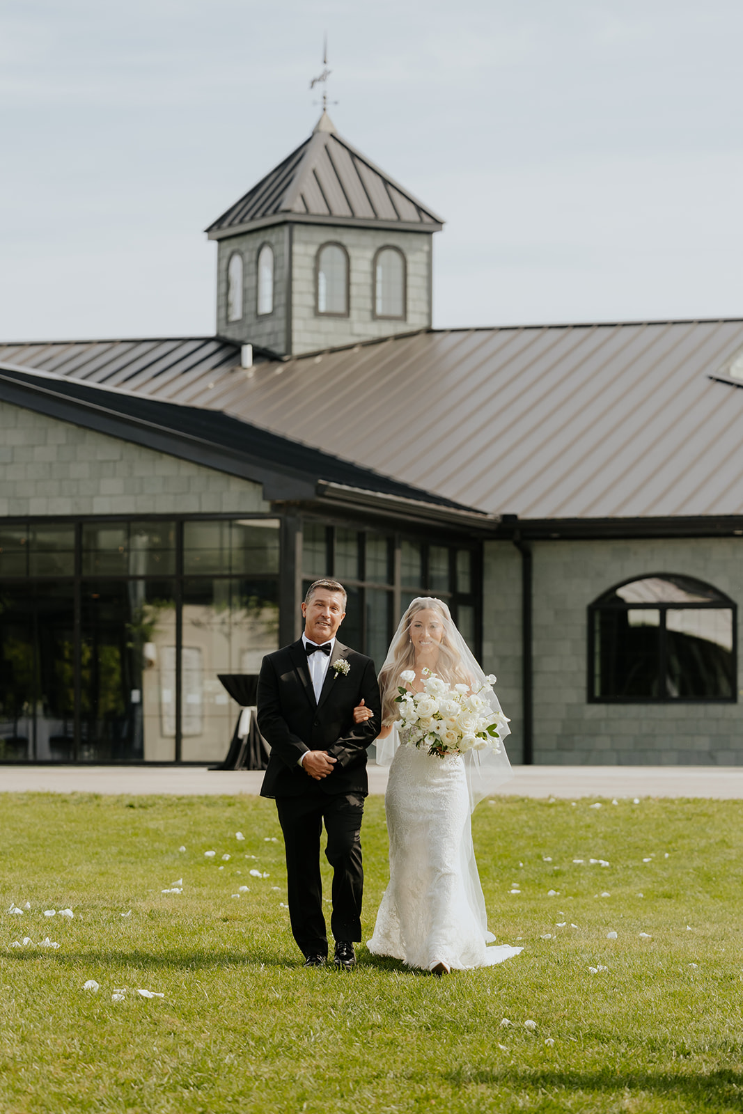 The bride's father walks her across the lawn toward the ceremony at The Clubhouse