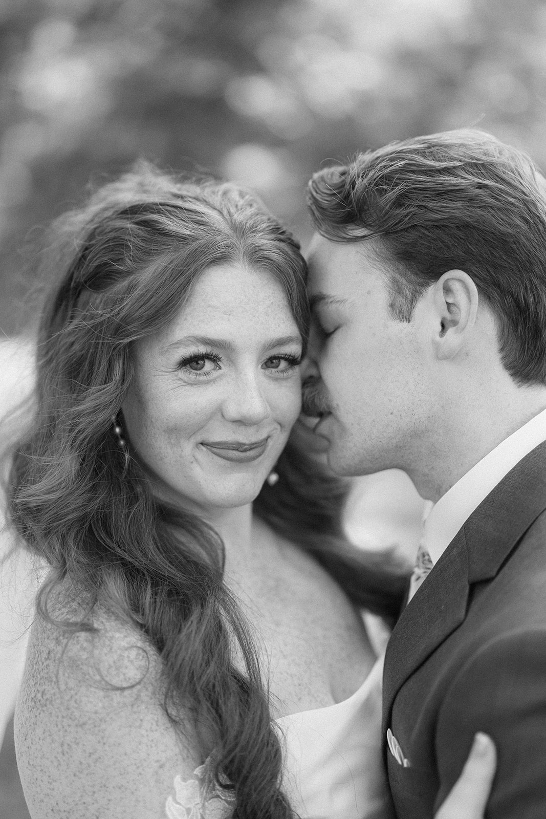 Black and white close-up of Maci and Matt, his face pressed to her cheek as she smiles