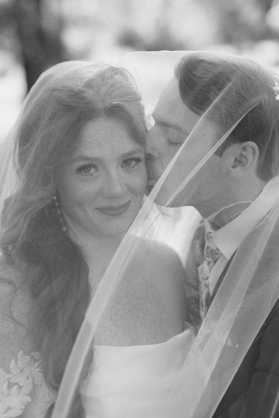 Black and white of Maci and Matt wrapped together under her veil