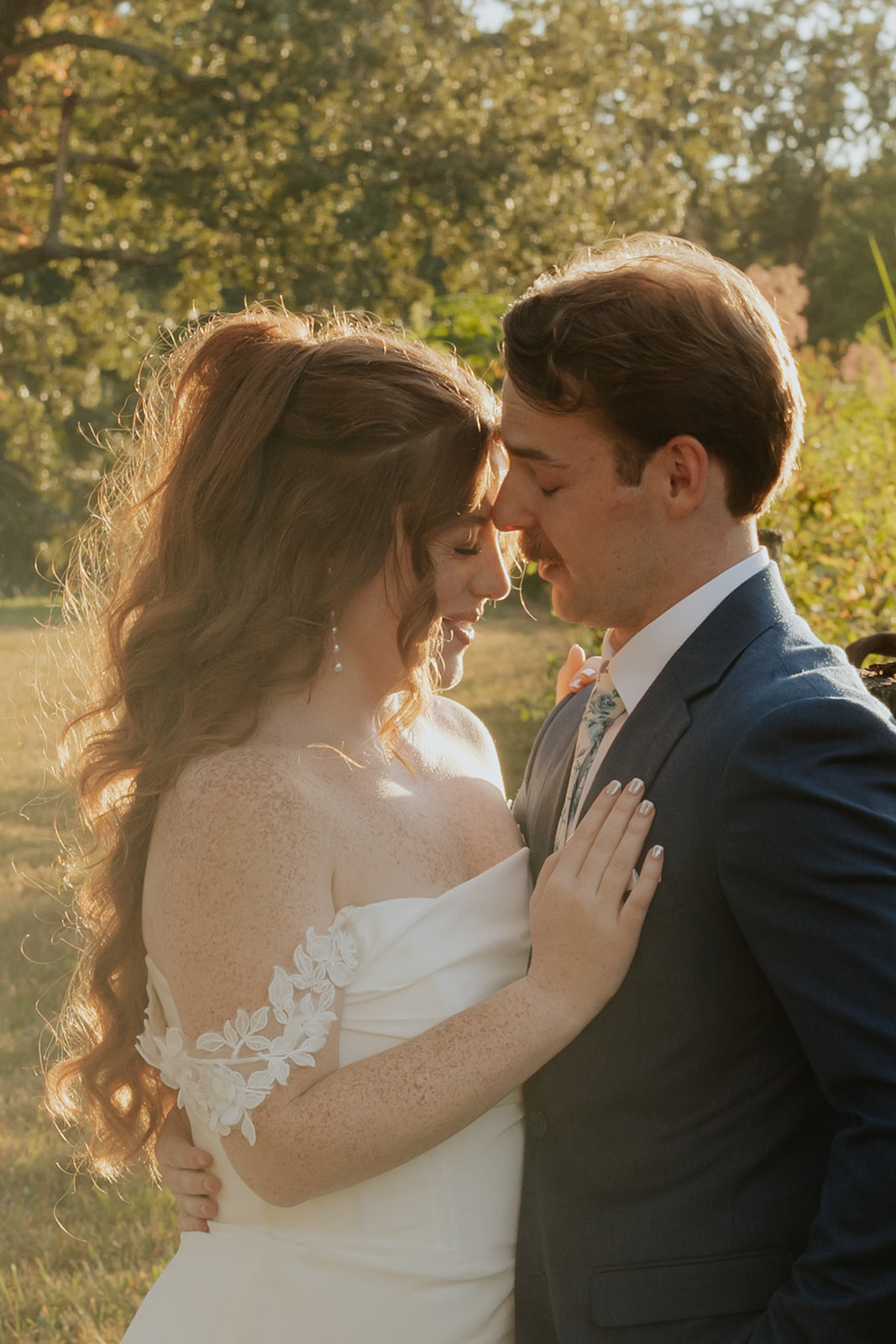 Maci and Matt lean into each other forehead to cheek in the golden hour light