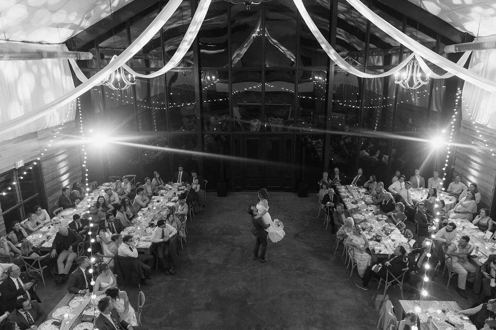 Black and white overhead view of the reception barn at Burdoc Farms with draped fabric and string lights